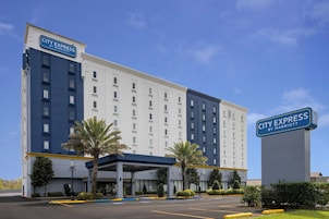 Un hotel City Express by Marriott con un diseño moderno, que cuenta con una entrada cubierta y un estacionamiento.