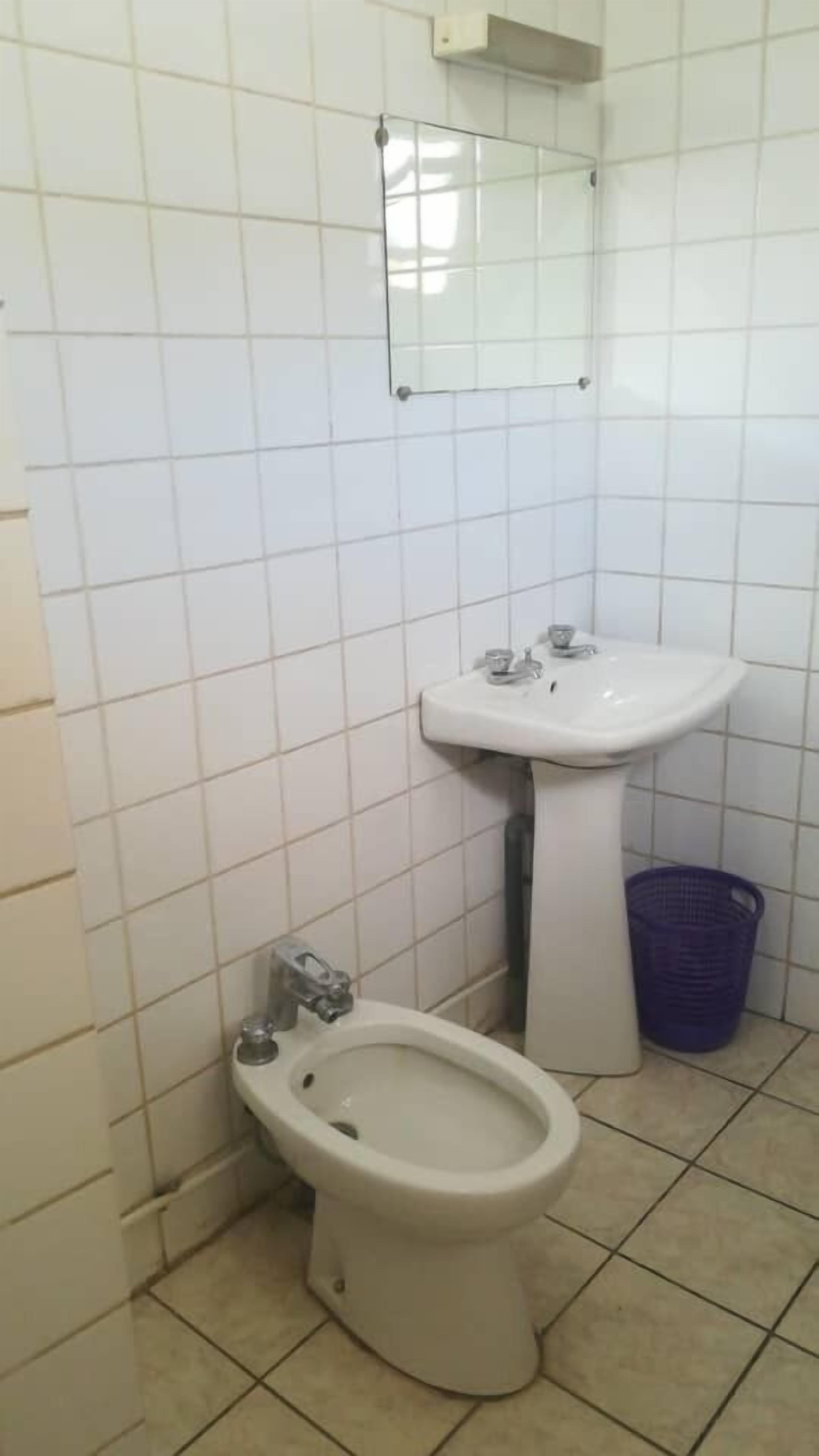 A small bathroom with a toilet, bidet, and sink.