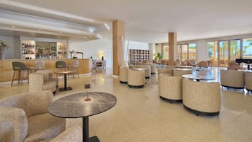 Eine geräumige Lobby mit Barbereich, Sitzgelegenheiten und großen Fenstern mit Blick.