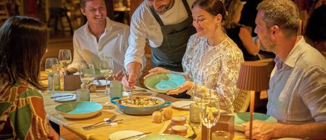 Una mesa de comedor dispuesta con platos, vasos y cubiertos, que sugiere un ambiente de restaurante.