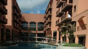Una piscina rodeada de edificios de varios pisos con balcones.