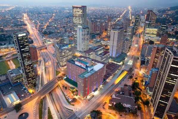 A cityscape with high-rise buildings, roads, and a highway interchange.