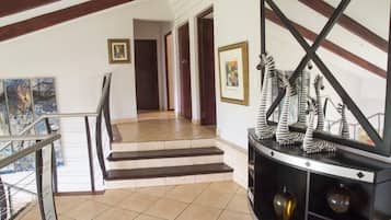 A staircase leading to a landing with a black console table and framed artwork.