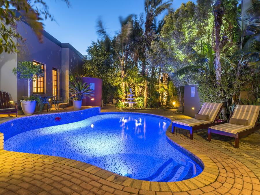 En säsongsöppen utomhuspool, parasoller och solstolar