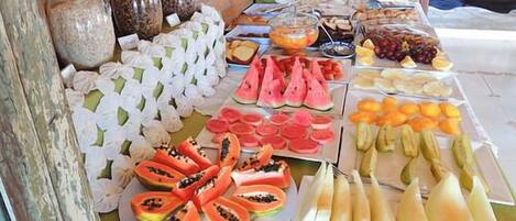 A buffet with various fruits and snacks, including watermelon, papaya, and mango.