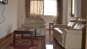 Un salon avec un canapé, une table basse et un téléviseur fixé au mur.