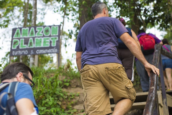 A group of people ascending a wooden staircase outdoors.