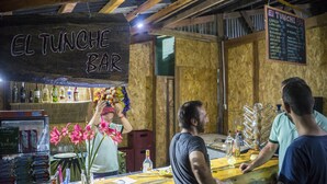 A bar with a wooden interior, a chalkboard sign reading "EL TUNCHE BAR", and a menu board above the bar. - Amazon Planet (Tambopata)