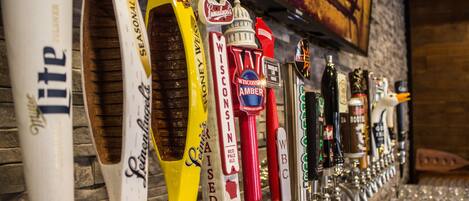 Una fila de grifos de cerveza con etiquetas como 'Leinenkugels', 'Leinenkugels elevada' y 'Ámbar de Wisconsin'.