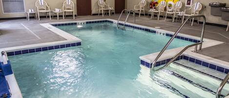 A swimming pool with a diving board, multiple chairs, and a lifeguard station.