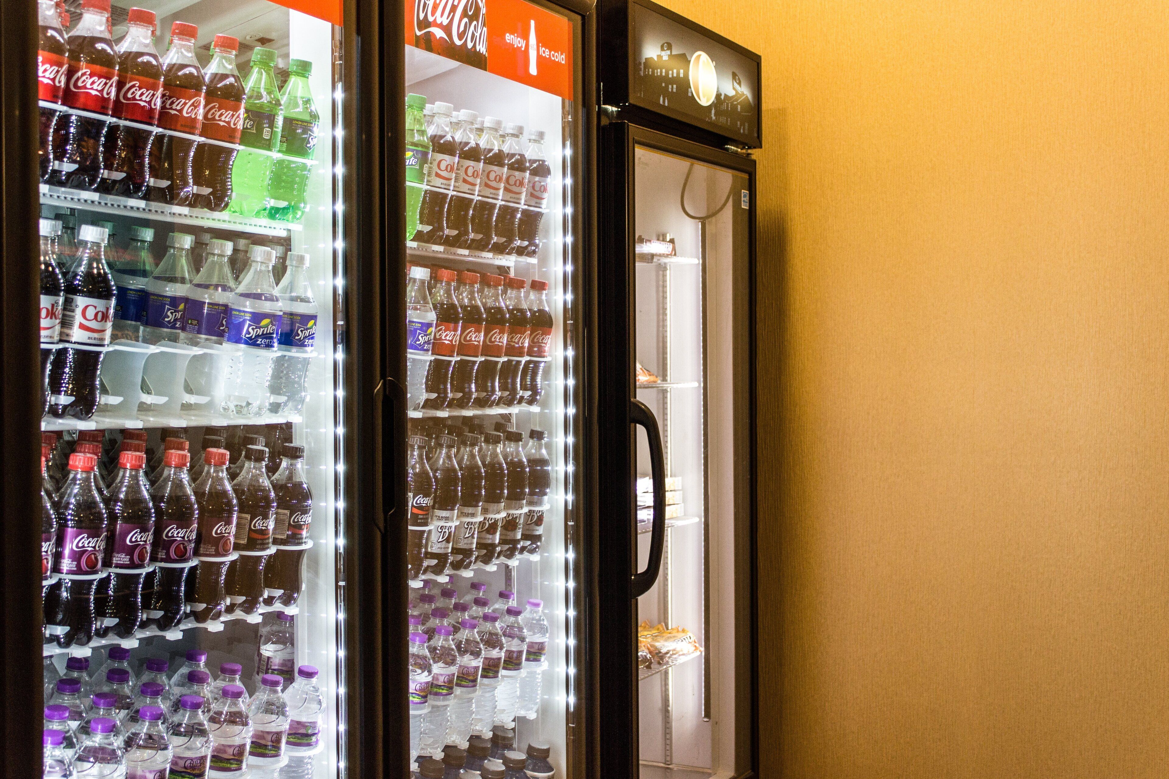 Egy automatás italbolt, amelyben különféle italok kaphatók, köztük Coca-Cola, Sprite és más üdítőitalok.
