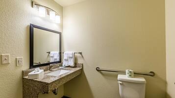 A bathroom with a sink, mirror, towel rack, and toilet.