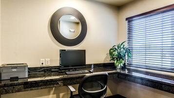 A modern office space with a desktop computer, printer, and chair.
