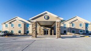 A building with a central entrance, stone pillars, and a clear blue sky.