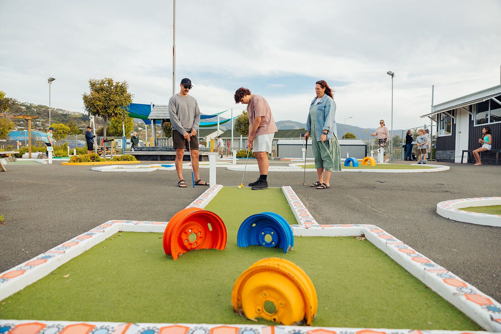A miniature golf course with a green playing surface and colorful obstacles.