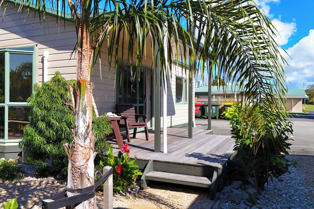 A house with a porch, a bench, and a small garden.