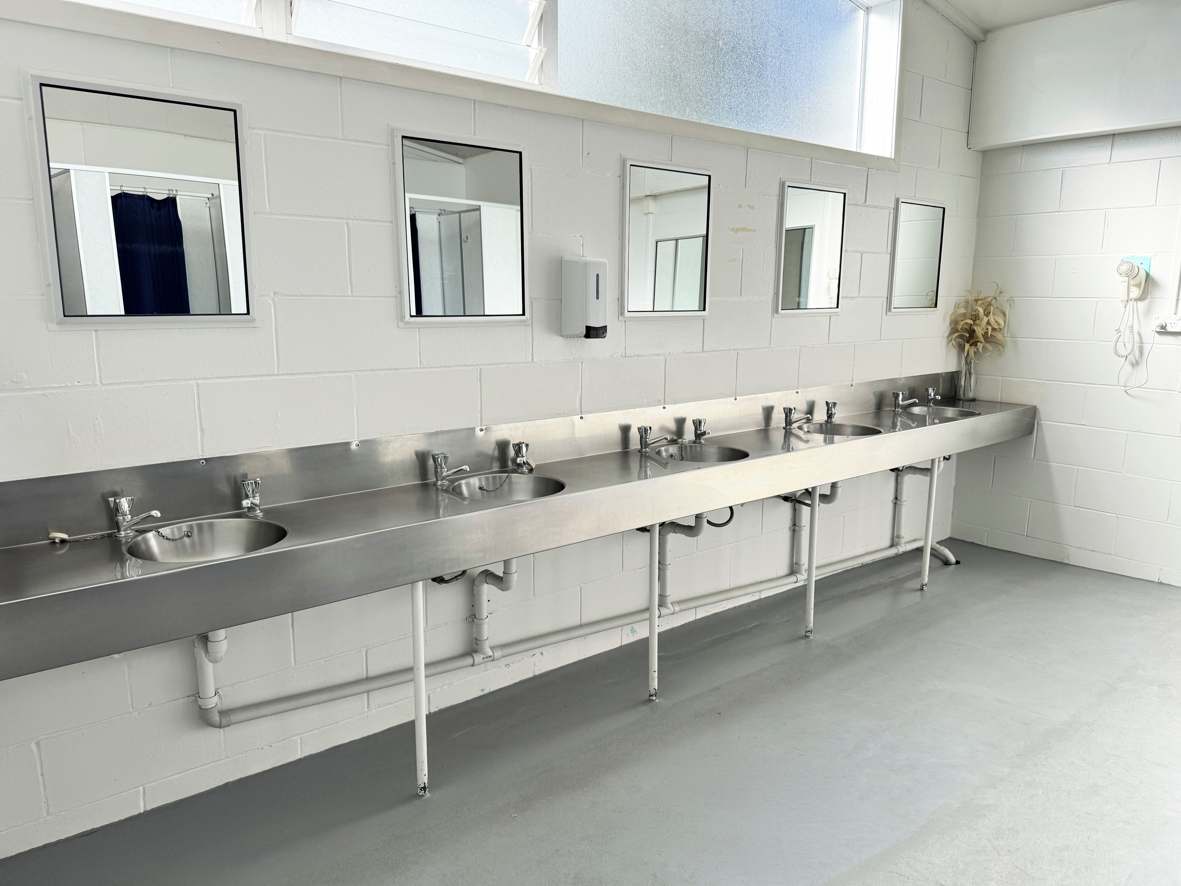 Des toilettes publiques équipées de plusieurs lavabos et de miroirs.