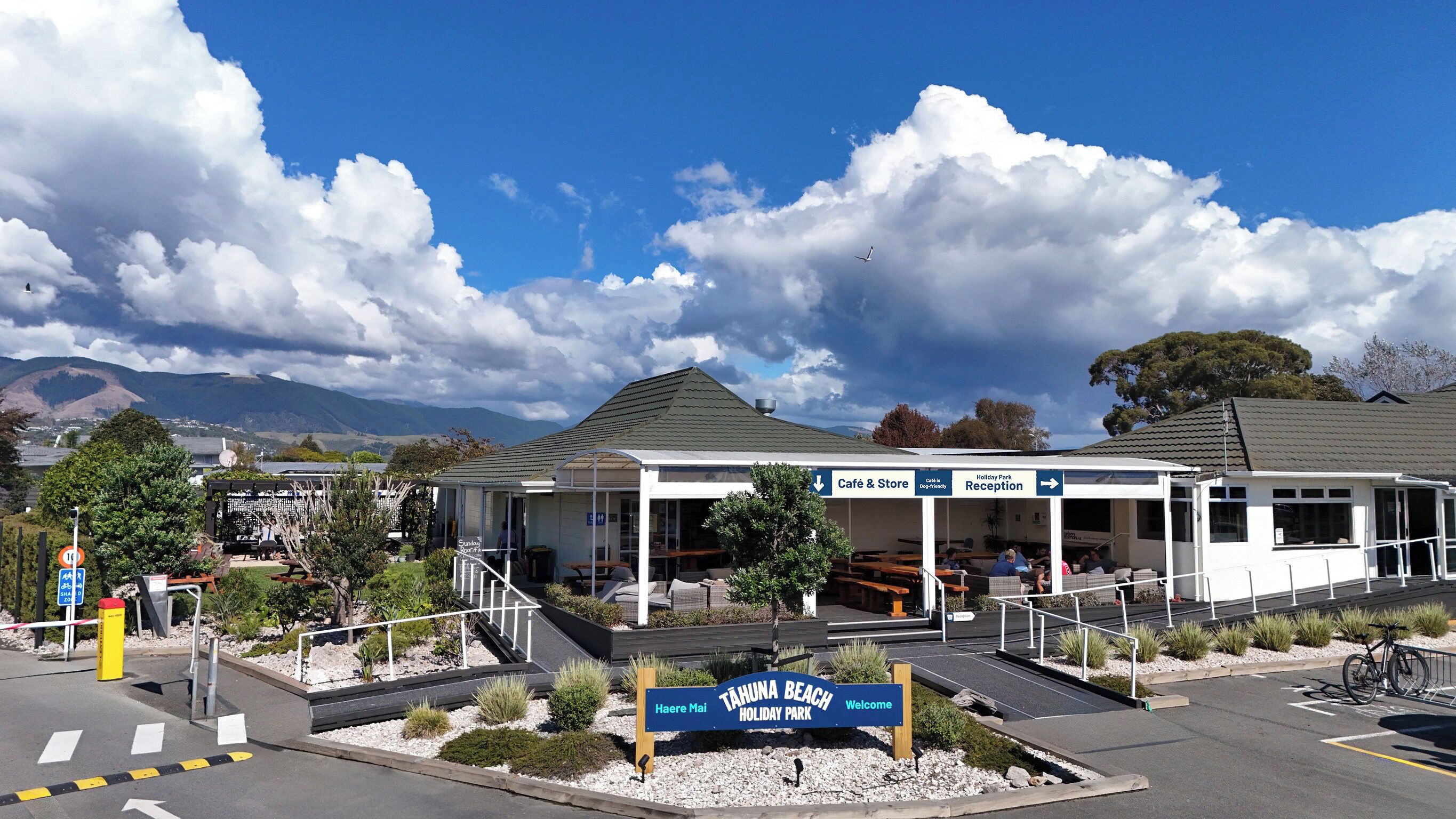 A café and store at TAHUNA BEACH HOLIDAY PARK with outdoor seating and a reception area.