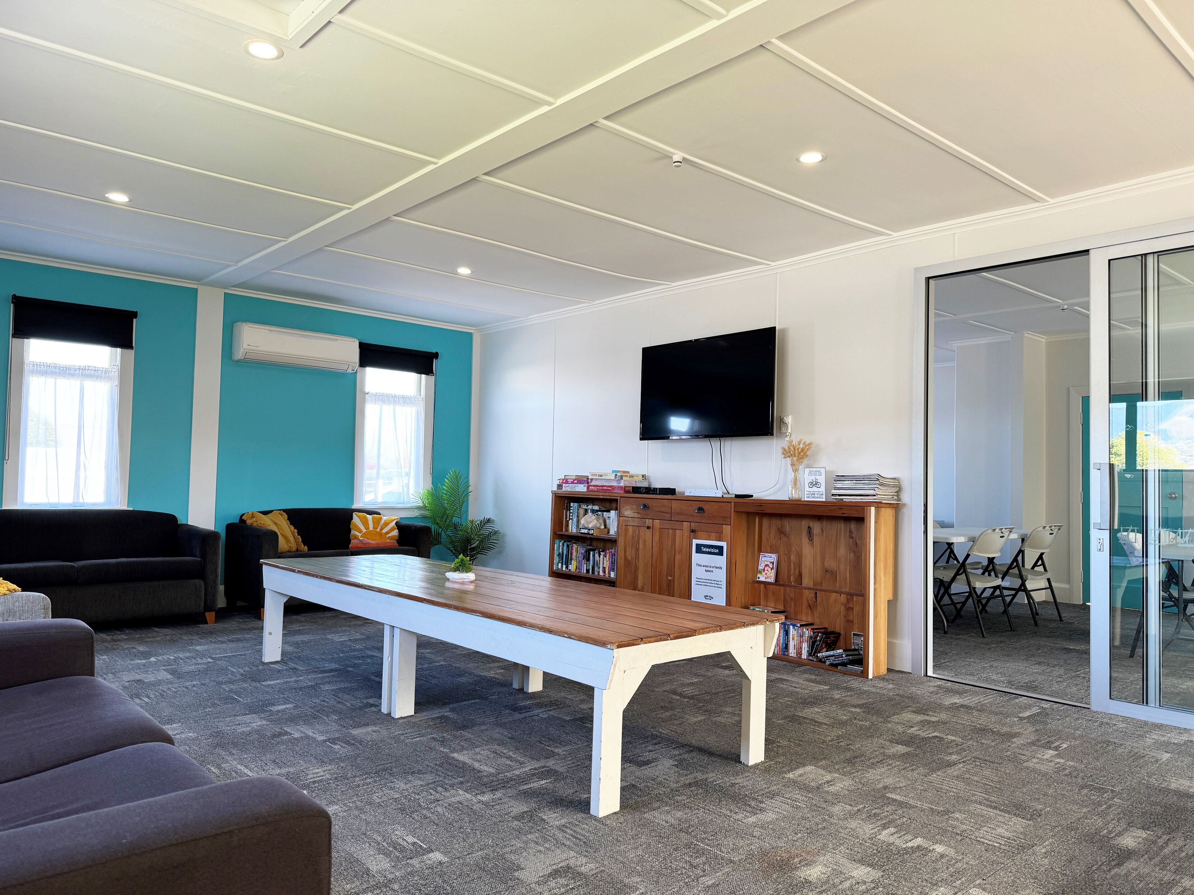 A modern living room with a sofa, a coffee table, and a TV mounted on the wall.