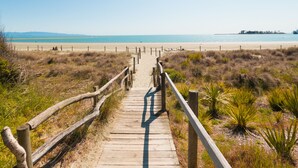 A wooden boardwalk leading to a beach with a clear sky. - Tahuna Beach Holiday Park  (Nelson)
