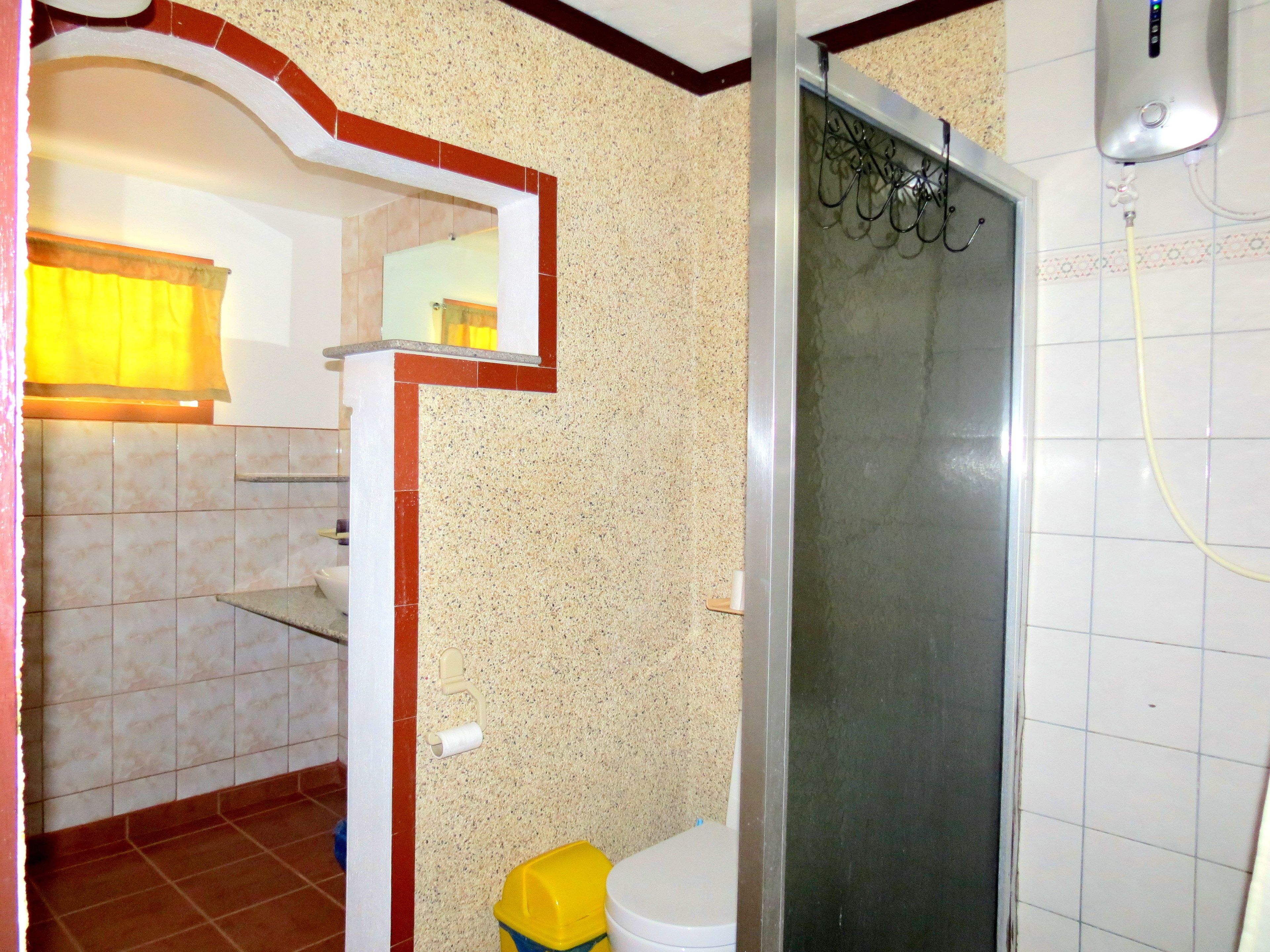 A bathroom with a shower, toilet, and sink.
