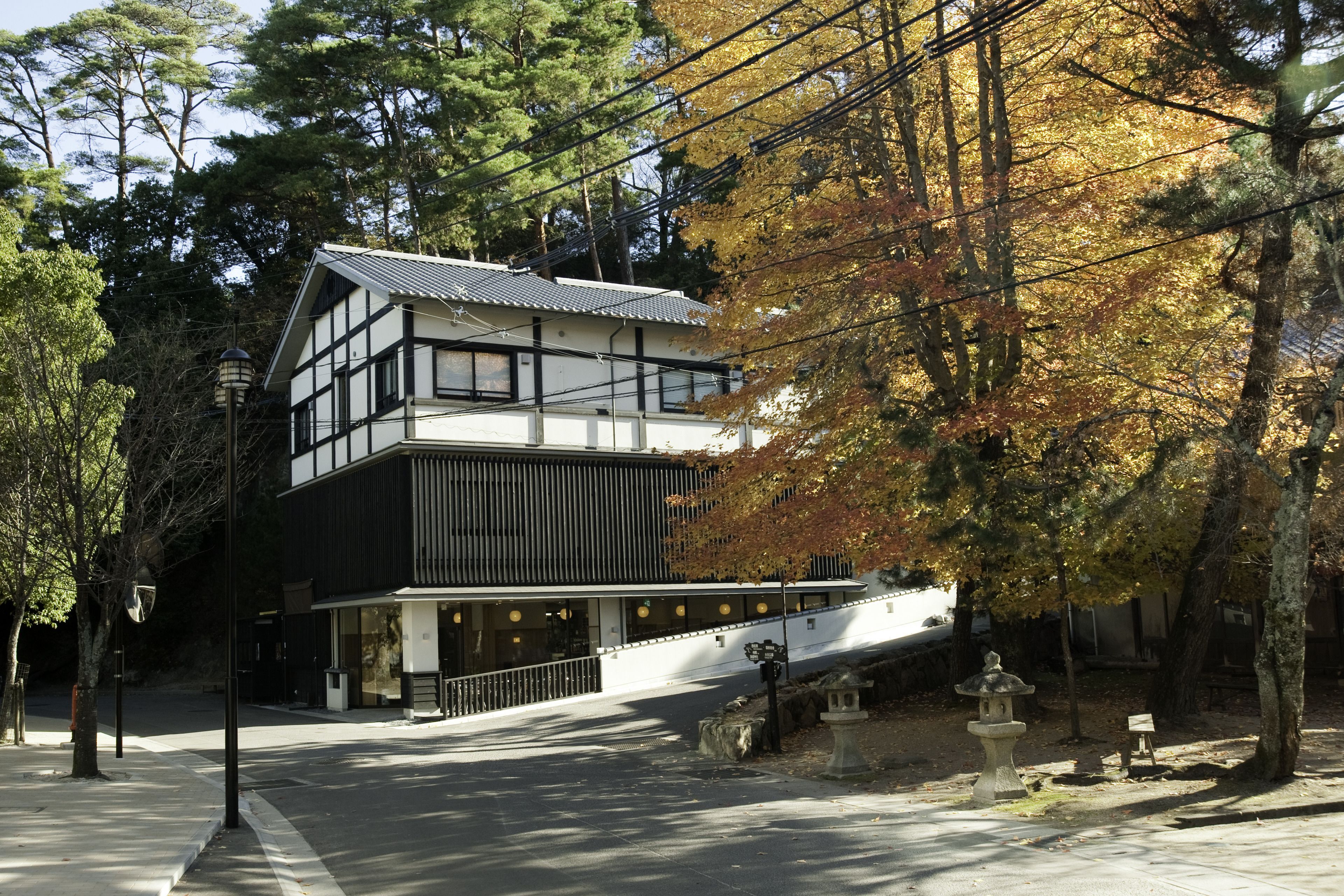 A two-story building with a modern design, featuring a combination of white and dark panels, and a sloped roof.