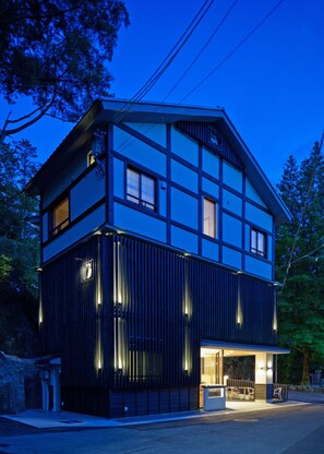 Una casa moderna de dos pisos con techo plano y ventanas amplias.