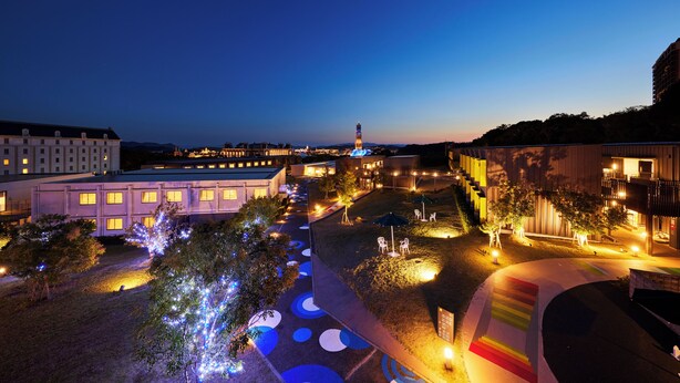 A nighttime view of a campus with illuminated pathways, buildings, and a prominent tower. - Hotel Rotterdam Huis Ten Bosch (Sasebo)