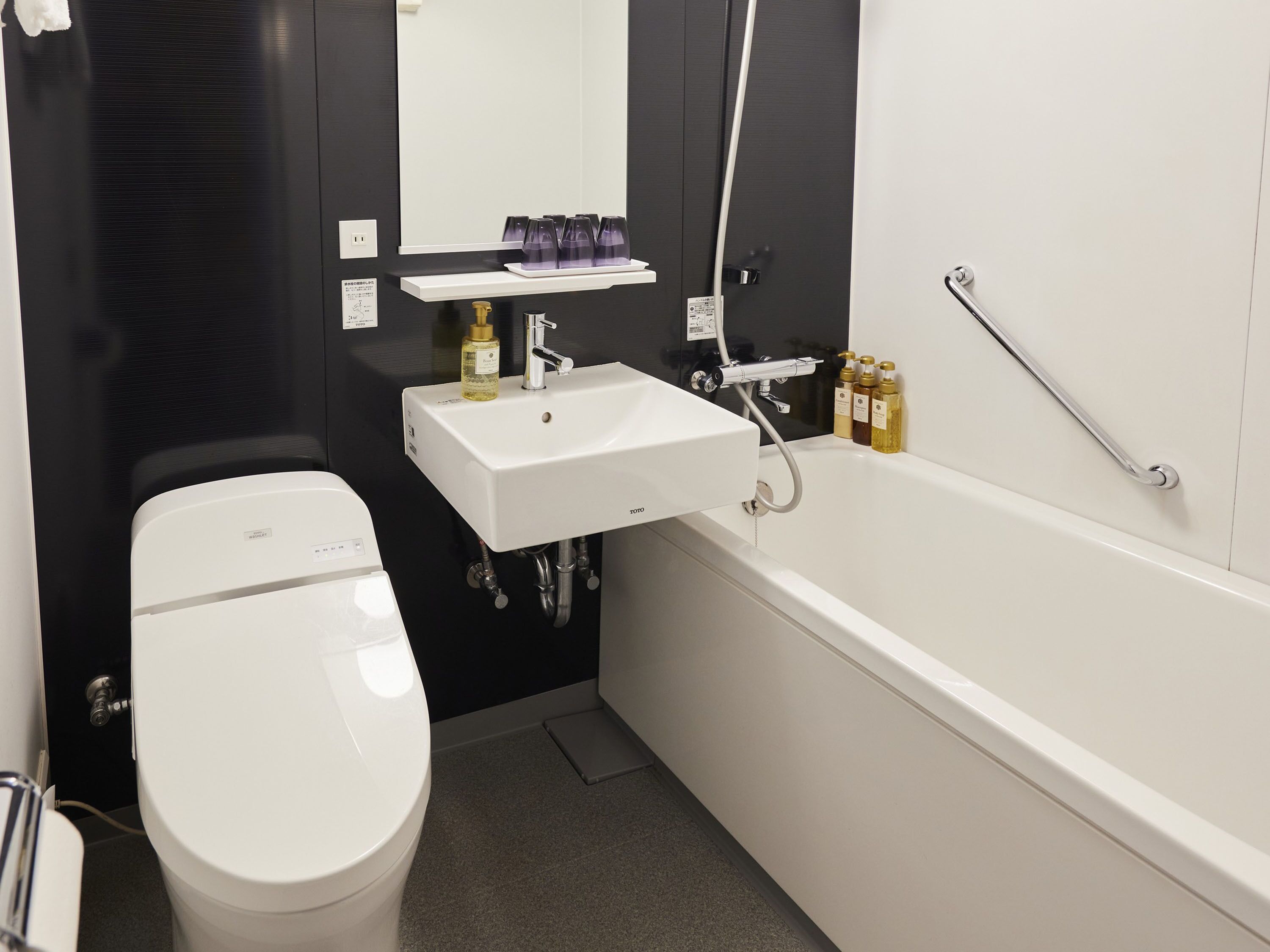 A modern bathroom with a white toilet, a sink, and a bathtub.