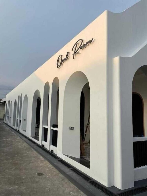 A building with a white facade and the name 'Orleans' in cursive script.