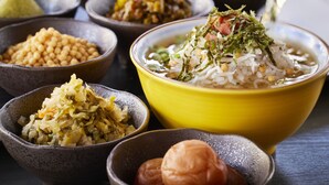 A variety of bowls containing different dishes, including rice, vegetables, and possibly some pickled items.