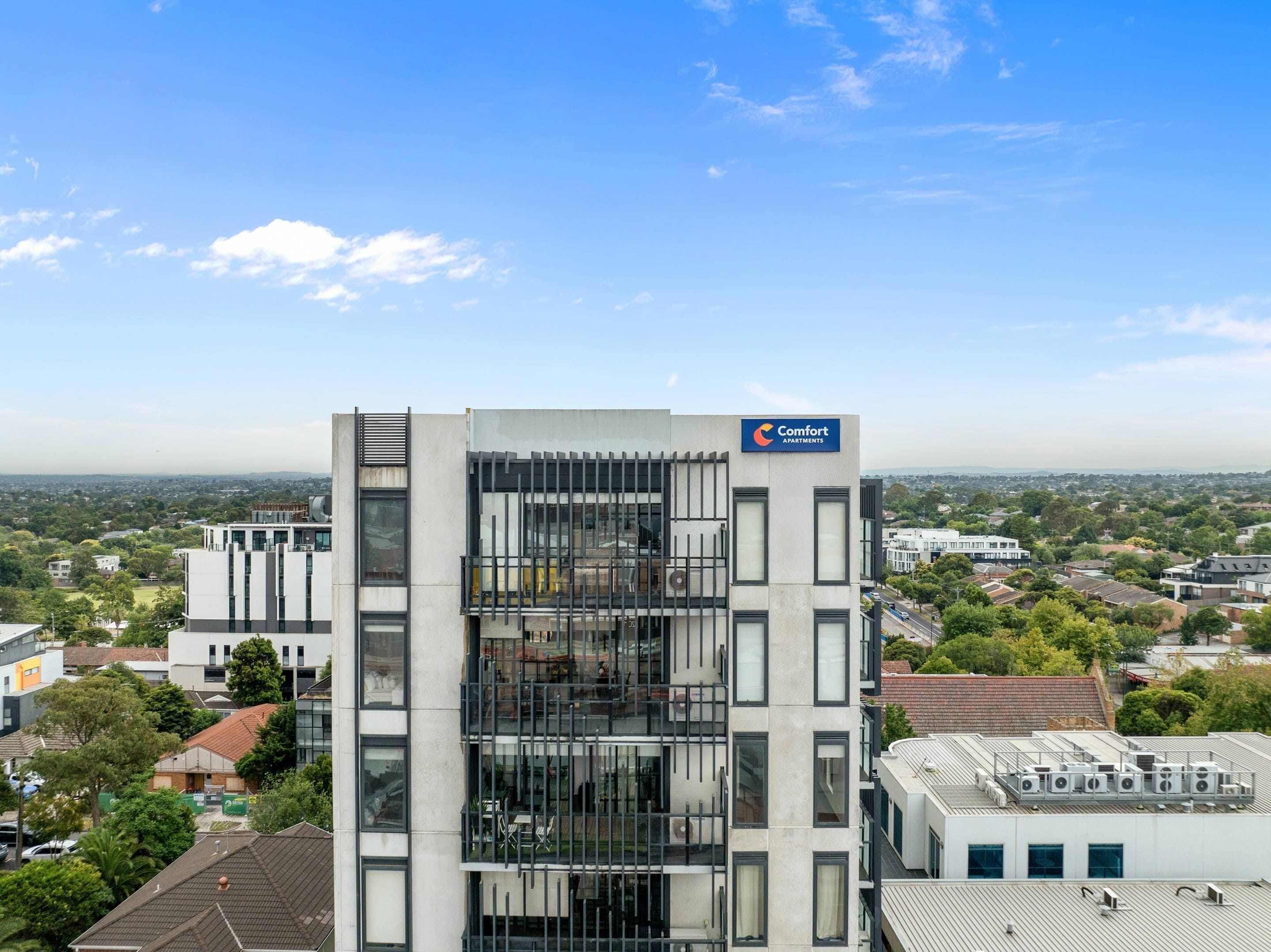 A multi-story building with a sign for 'Comfort Apartments.'