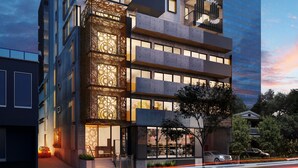 A modern multi-story building with a unique facade featuring geometric patterns and balconies. - Comfort Apartments Box Hill (Box Hill)