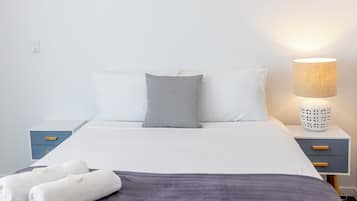 Escritorio, cortinas blackout y tabla de planchar con plancha