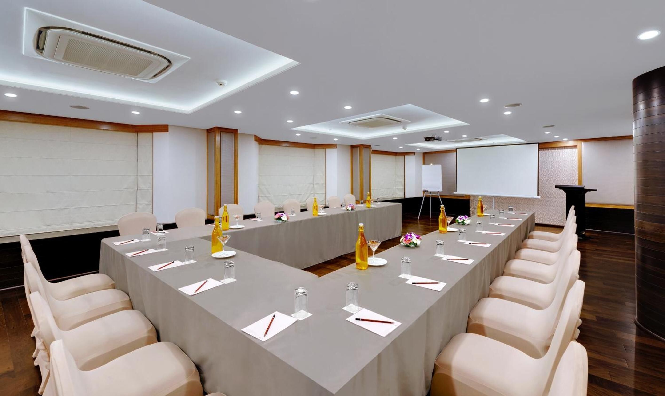 A conference room with a long table, chairs, and a podium.