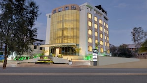 A modern hotel with a curved facade, multiple floors, and a well-lit entrance. - The Fern Residency, MIDC - Pune (Pune)