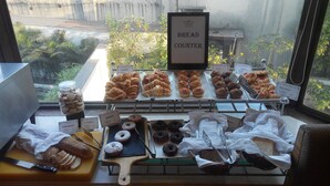 A bakery display with various baked goods and a sign indicating a bread counter. - The Fern Residency, MIDC - Pune (Pune)