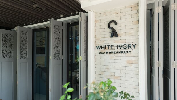 A hotel entrance with a sign reading "WHITE IVORY BED & BREAKFAST". - White Ivory Bed & Breakfast (Bangkok)
