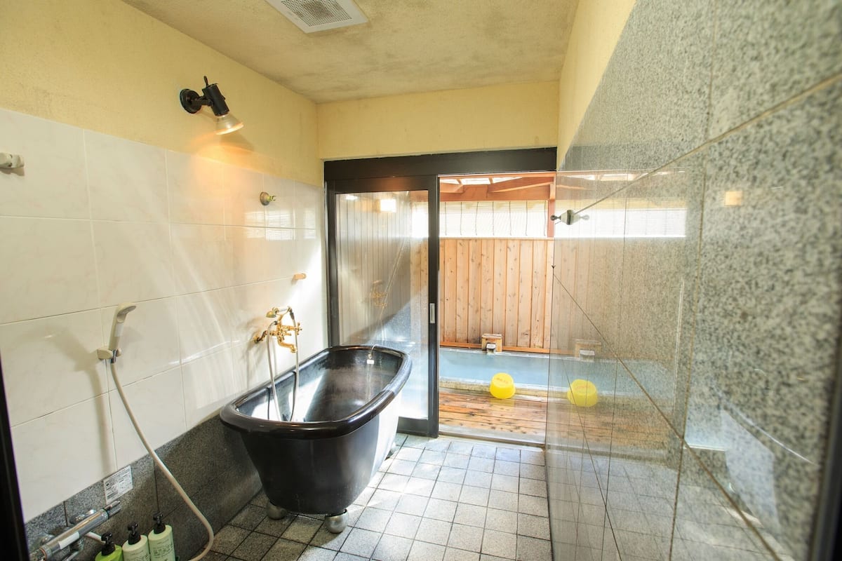 A bathroom with a bathtub, a shower, and a glass-enclosed shower area.