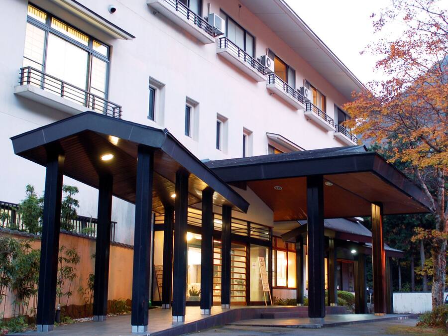 A modern hotel with a covered entrance, multiple floors, and a balcony with railings.