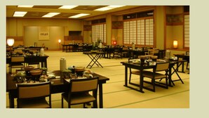 A spacious banquet hall with multiple tables set for dining, featuring traditional Japanese decor and tatami mats. - Kinokuniya Ryokan (Hakone)