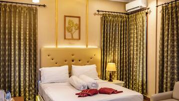 Une chambre d’hôtel avec un grand lit, une table de chevet, une lampe et un canapé.