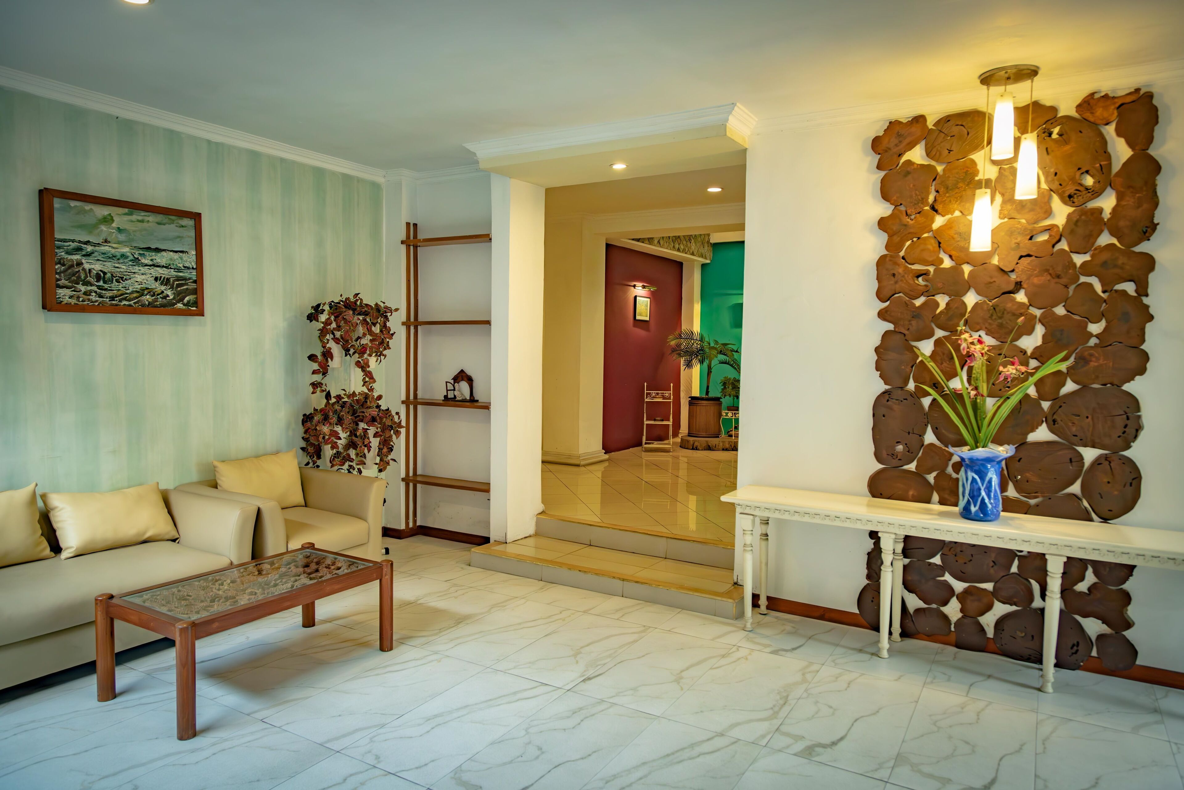 A living room with a sofa, coffee table, and a decorative wall with a stone-like pattern.
