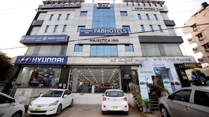 En bygning med flere etager, der viser skiltning for FabHotels, Majestic Inn, Hyundai og KIN United Hyundai.