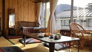 A traditional Japanese room with tatami flooring, a low table, and two wooden chairs. - Fukushimakan (Hakone)