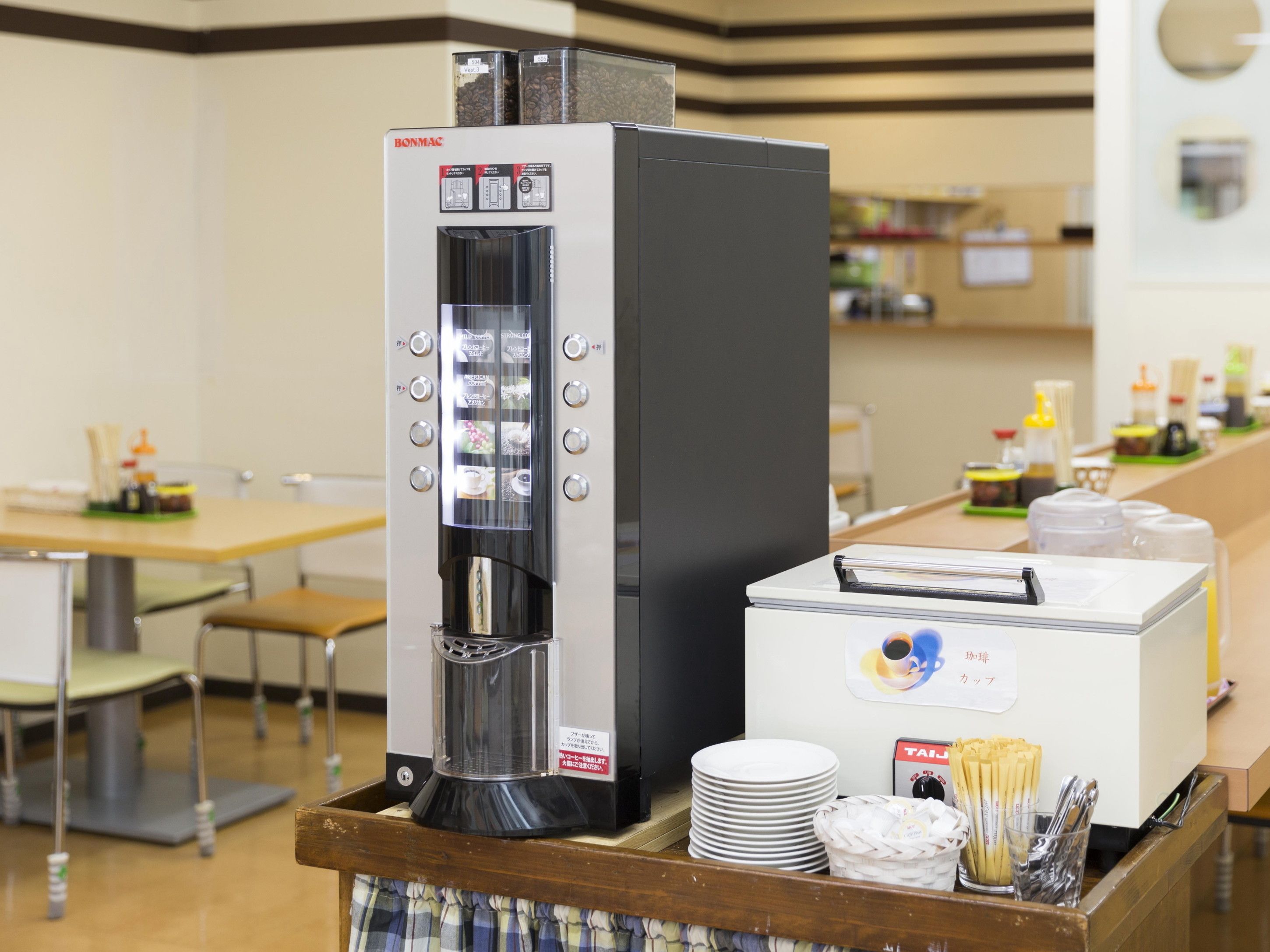 Eine Kaffeemaschine und ein Kühlschrank in einem Café.