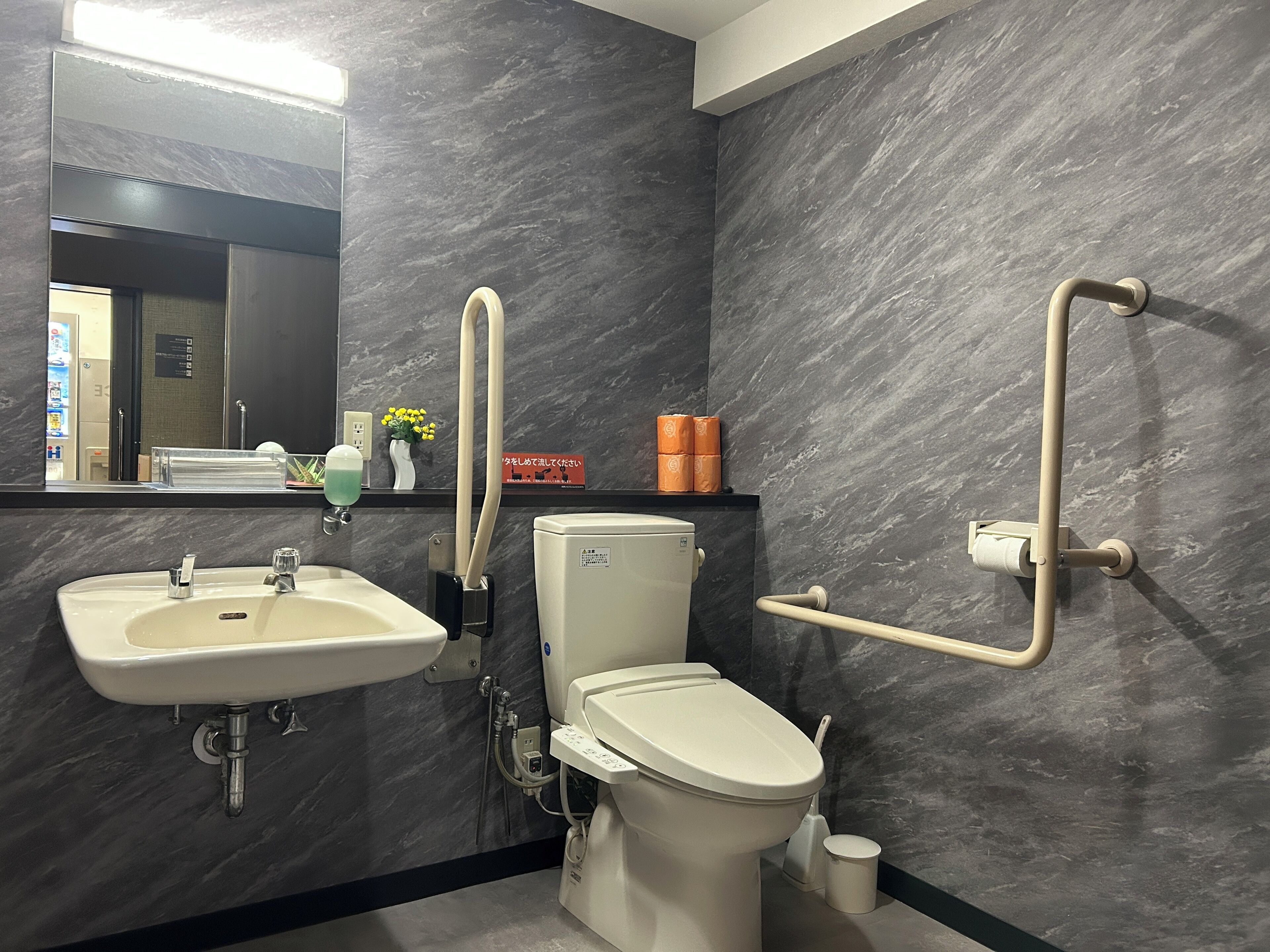 A modern bathroom with a sink, toilet, and bidet.