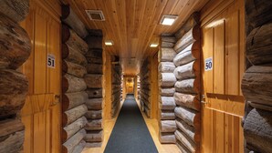 Pasillo de un hotel de estilo cabaña de troncos, con paredes y puertas de madera, con los números 51 y 50.