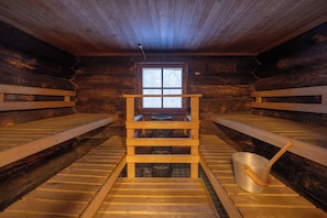 A wooden cabin with a central wooden bench and a window.