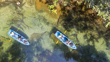 Two kayaks on a clear water body with surrounding vegetation.